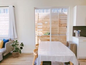 Relax in this inviting space with a dining table, comfortable sofa, and potted plant.