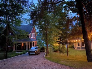 A house with a covered porch, a driveway, and a car parked in front.