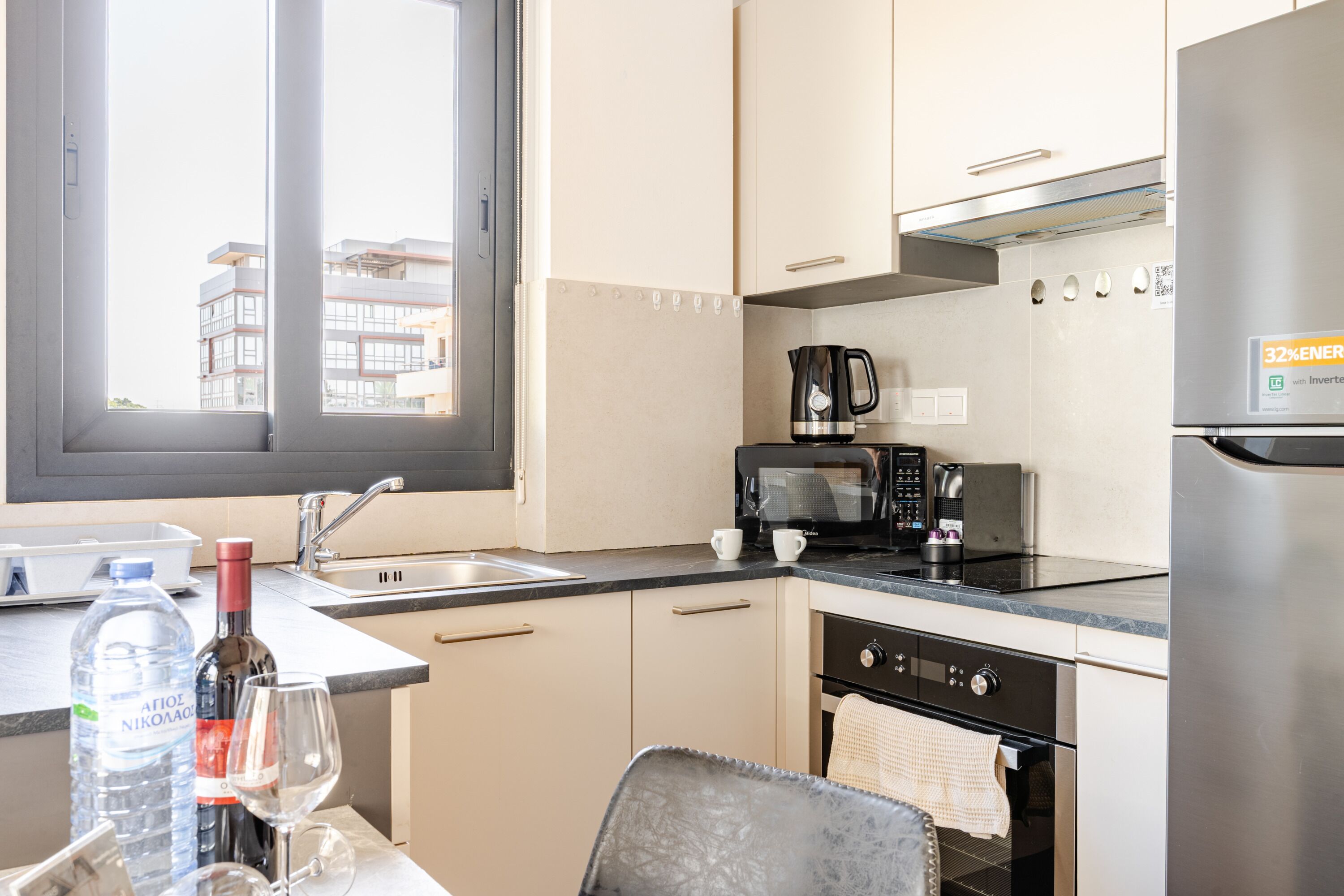 Een moderne keuken met een roestvrijstalen koelkast, een koffiezetapparaat en een magnetron.