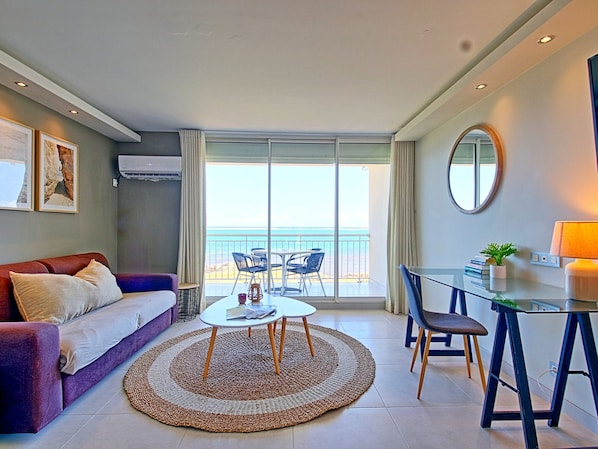 A modern hotel room with a sofa, a dining table, and a view of the sea. - Spacious Studio with View and Pool in Mont Vernon (Saint-Martin)