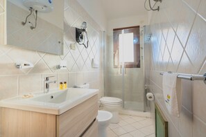 Une salle de bain moderne avec un grand lavabo, des toilettes et une douche à parois de verre.