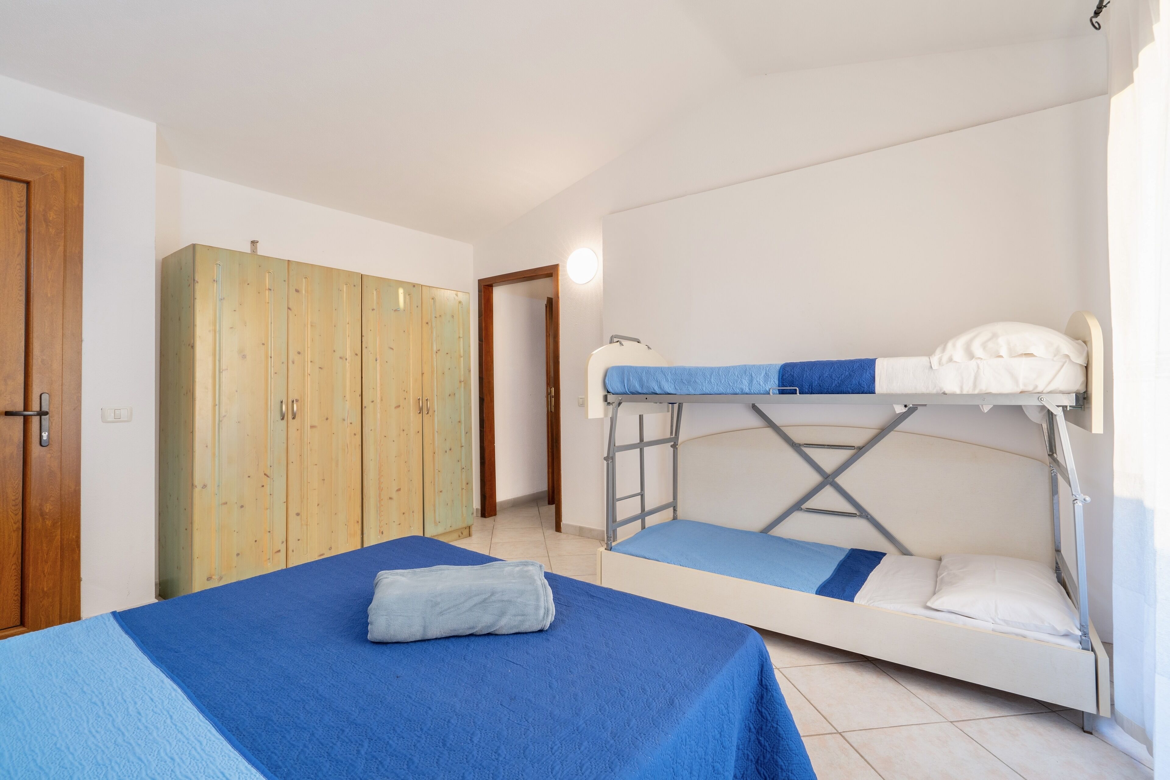 Una habitación con dos camas, un armario y una puerta.