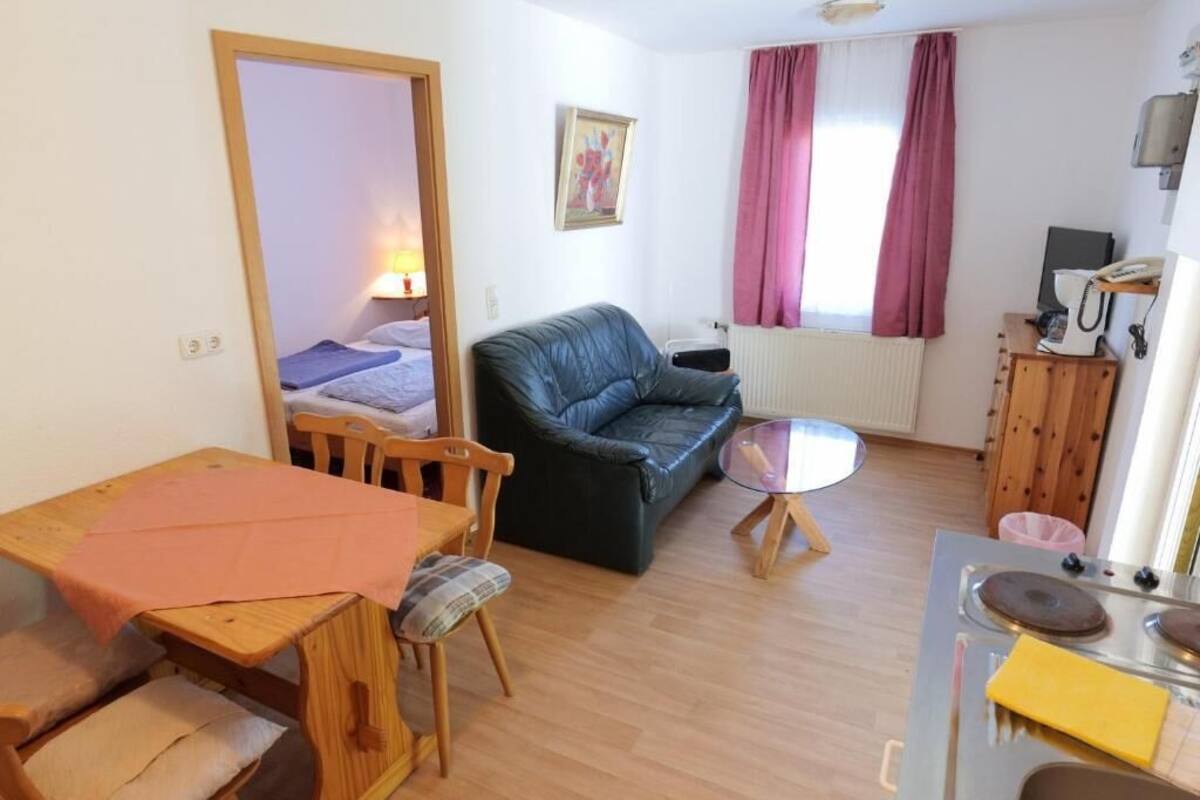 Un espai vital reduït amb llit, sofà, taula de dinar i petita cuina.