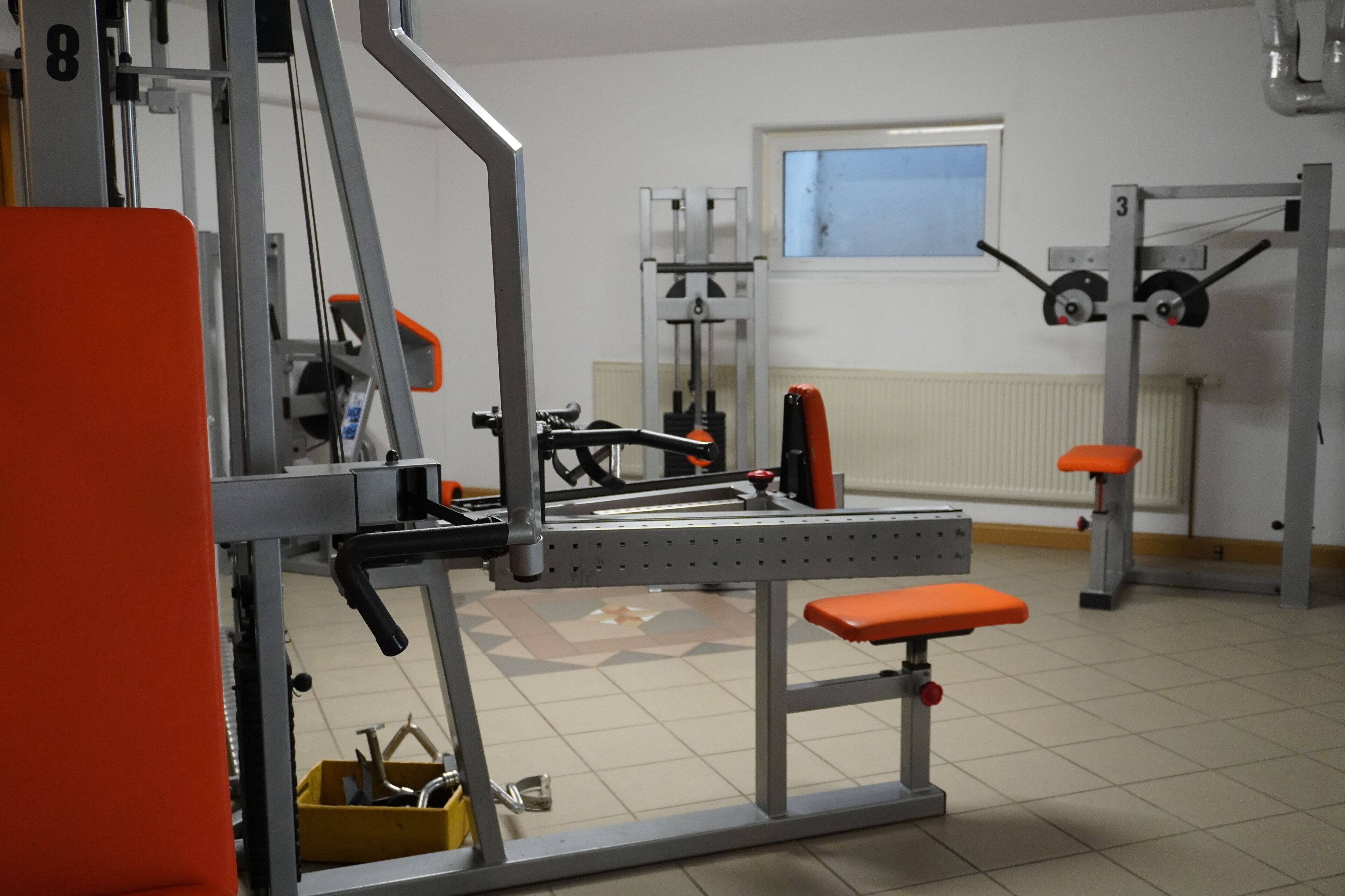 A gym with various exercise equipment, including benches and weight machines.