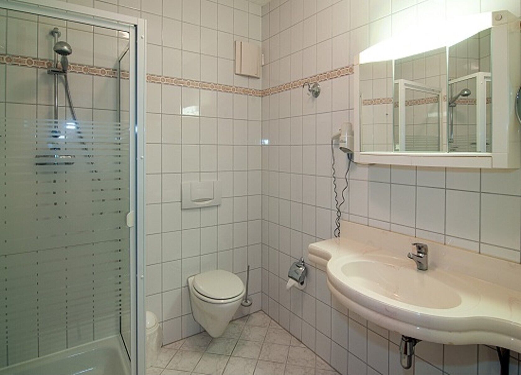 Ein Badezimmer mit Dusche, Toilette und Waschbecken.