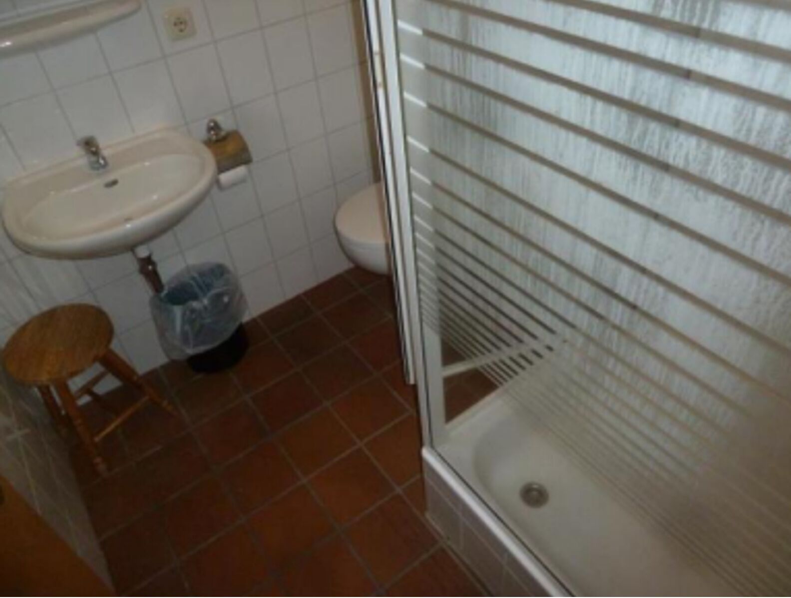 Un baño con lavamanos, inodoro y ducha.