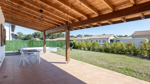 A covered patio with a pool, outdoor furniture, and a view of neighboring houses. - Belle Maison Landaise Prés des Plages (Tosse)