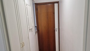 A hallway with wooden flooring, white walls, and a wooden door at the end. - À Louer Dans le Centre de Boulogne-billancourt à 10 mn en bus de Paris16éme (Boulogne-Billancourt)