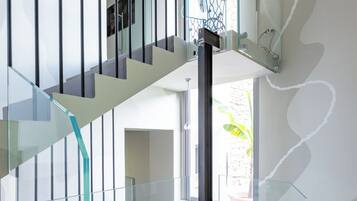 A modern staircase with glass railings and a clear view of the lower level.
