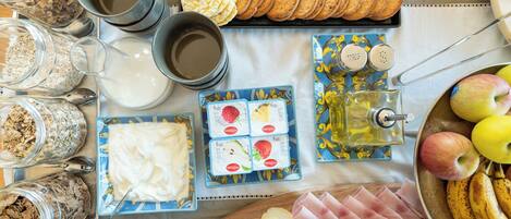 A breakfast table with various food items, including bread, eggs, cheese, and fruits.