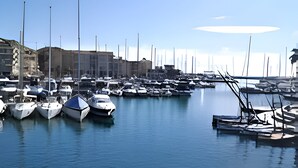A marina with boats docked, calm water, and buildings in the background. - Coin de Paradis Avec Piscine (Fréjus)