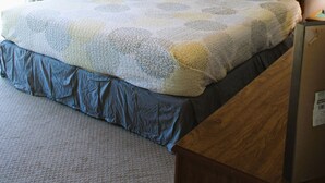 Ein Schlafzimmer mit einem Bett, einem Deckenventilator, zwei Nachttischlampen und einem Fenster.