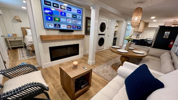 A modern living room with a flat-screen TV, a fireplace, a sofa, and a coffee table. - Albertville Historic Charmer (Albertville)