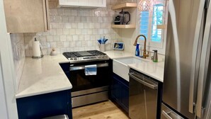 A modern kitchen with a stainless steel refrigerator, a built-in oven, a dishwasher, and a sink. - Albertville Historic Charmer (Albertville)