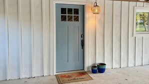 A light blue door with a window, a welcome mat, and two blue pots on the porch. - Albertville Historic Charmer (Albertville)