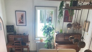 A living room with a beige sofa, a wooden coffee table, and a dining area with a wooden table and chairs. - Authentic charm in Corbas: 120m² of comfort (Corbas)