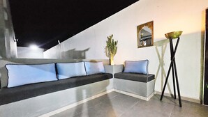 Ein modernes Wohnzimmer mit einem Ecksofa, einer Topfpflanze und einer Stehlampe.
