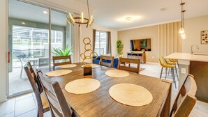 A dining area with a wooden table, chairs, and a chandelier.