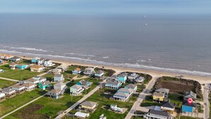 Zona residencial costera con casas, una playa y una carretera.