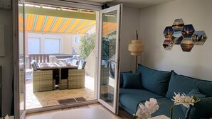 Una sala de estar con una puerta corrediza de vidrio que da a un patio al aire libre.