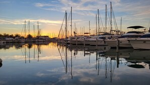 Un puerto deportivo con varios yates amarrados en aguas tranquilas que reflejan el cielo.