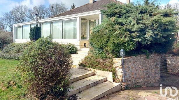 Een modern huis met een glazen gevel, stenen trappen en een stenen muur.