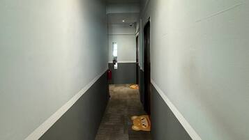 A narrow hallway with grey walls and a patterned carpet.
