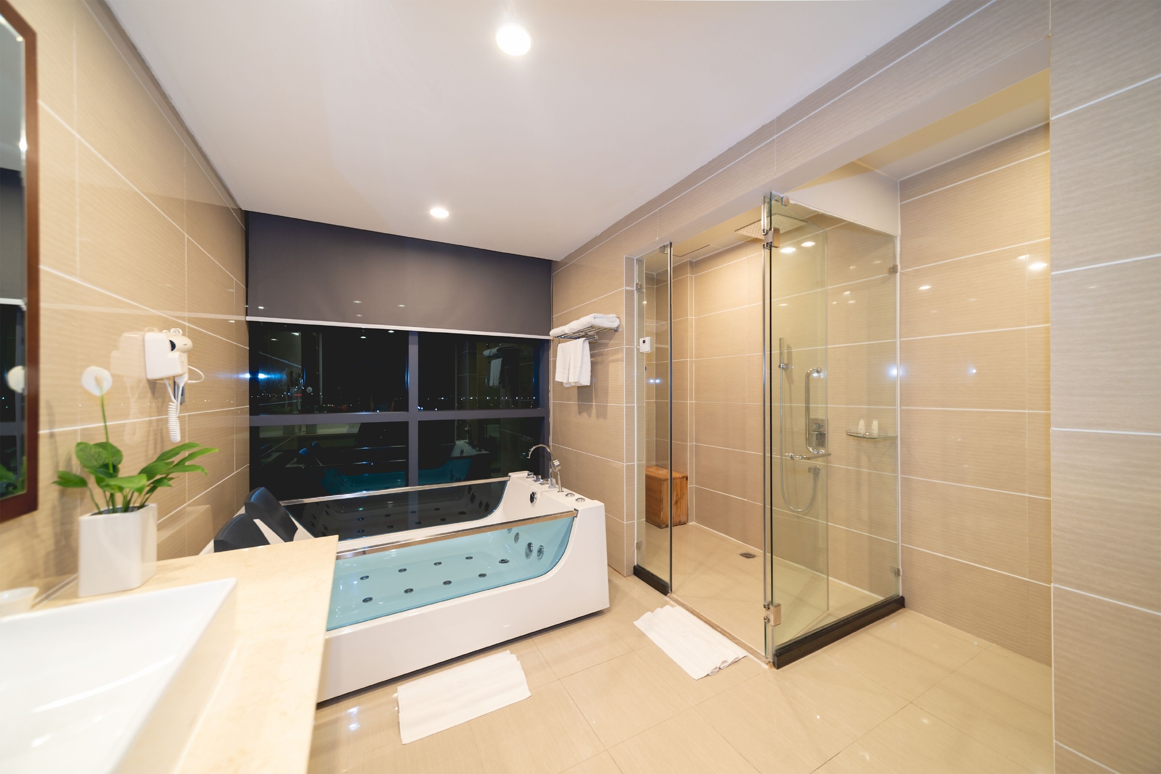 Grand tweepersoonskamer | Badkamer | Een douche, een regendouche, designer toiletartikelen, een haardroger