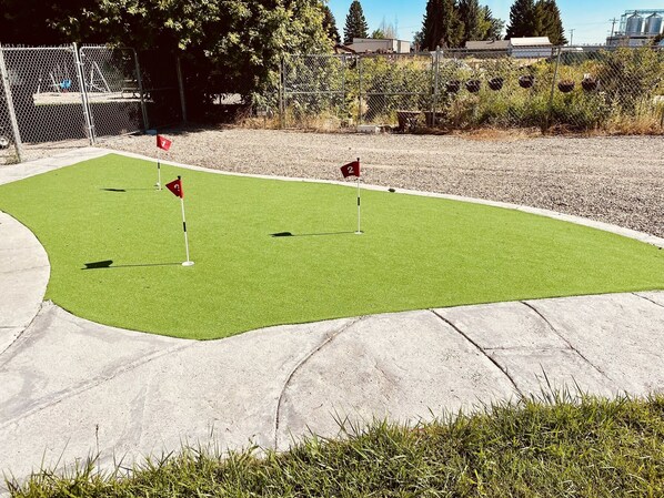 Un parcours de mini-golf avec deux trous signalés par des drapeaux rouges.