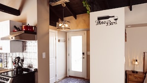 A kitchen with a stove, a red pot, and a hanging light fixture. - The Wine House (Warwick)