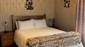 Um quarto aconchegante com uma cama de madeira, um painel decorativo na parede e um cobertor texturizado exclusivo.