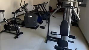 Uma academia com diversos equipamentos de exercício, incluindo esteiras, bicicletas ergométricas e aparelhos de musculação.