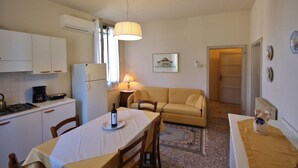 A compact kitchen with a dining table, chairs, a coffee maker, and a refrigerator. - Il Castello (Barbarano Vicentino)