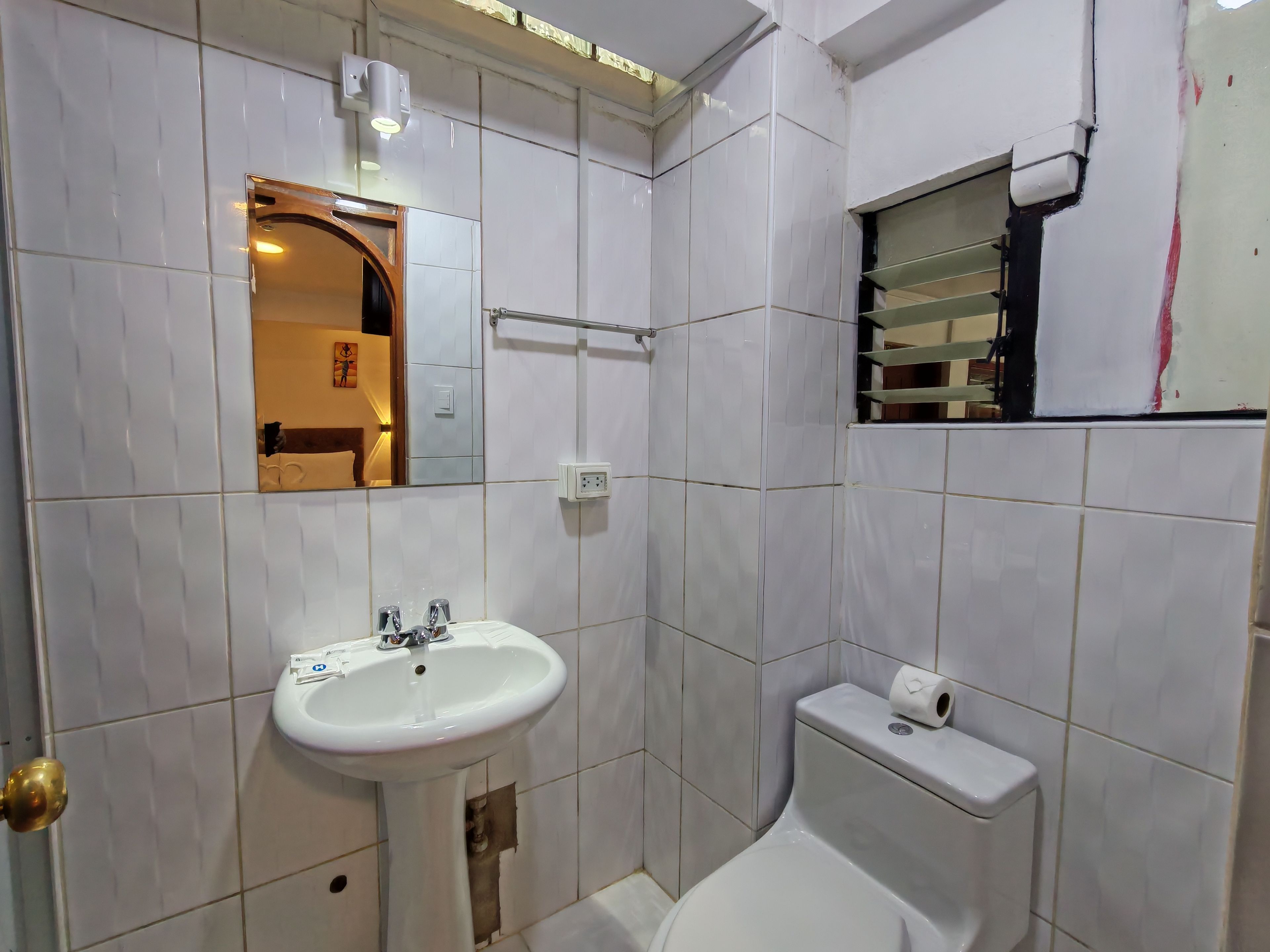 A bathroom with a sink, toilet, and a mirror.