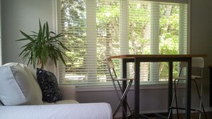 Un salon avec un canapé blanc, une table en bois et une plante en pot.