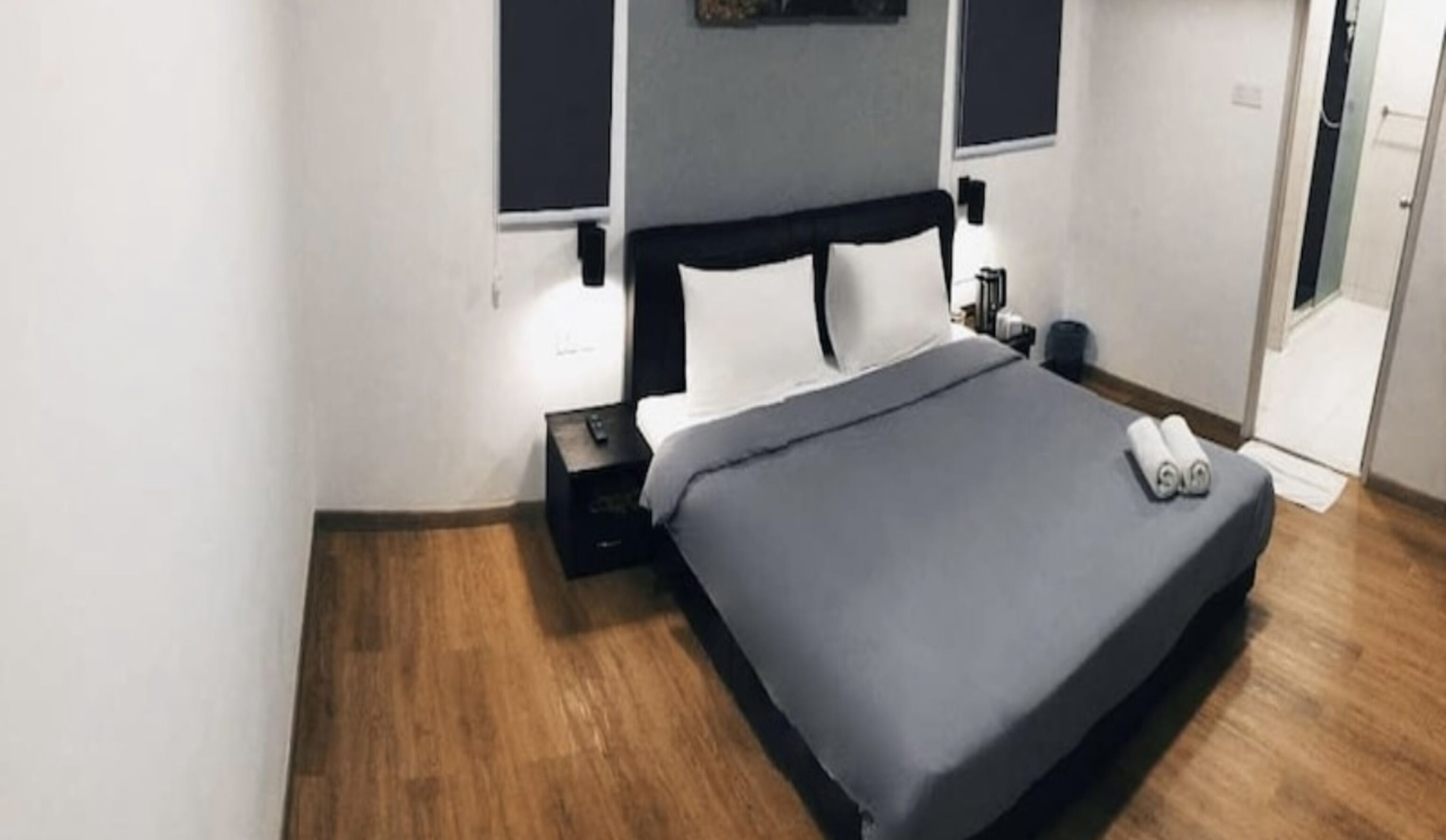 A bedroom with a bed, bedside table, and a nightstand.