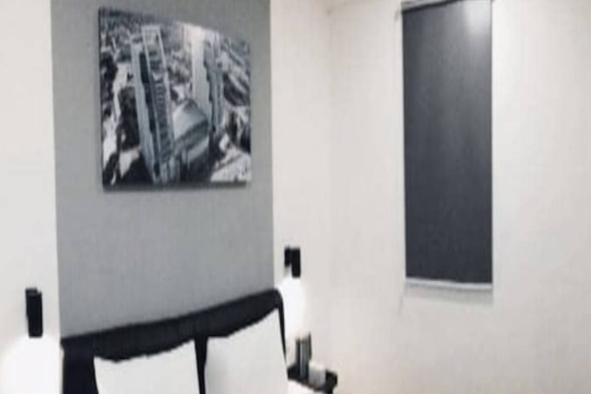 A room with a bed, a blackboard on the wall, and a window.
