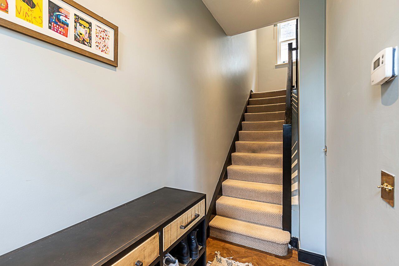A staircase with carpeted steps leading to a landing.