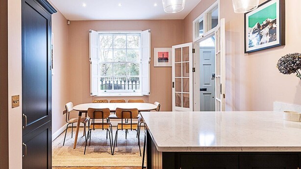 A kitchen with a dining table, chairs, a large window, and cabinets. - Paradise Row Townhouse (London)