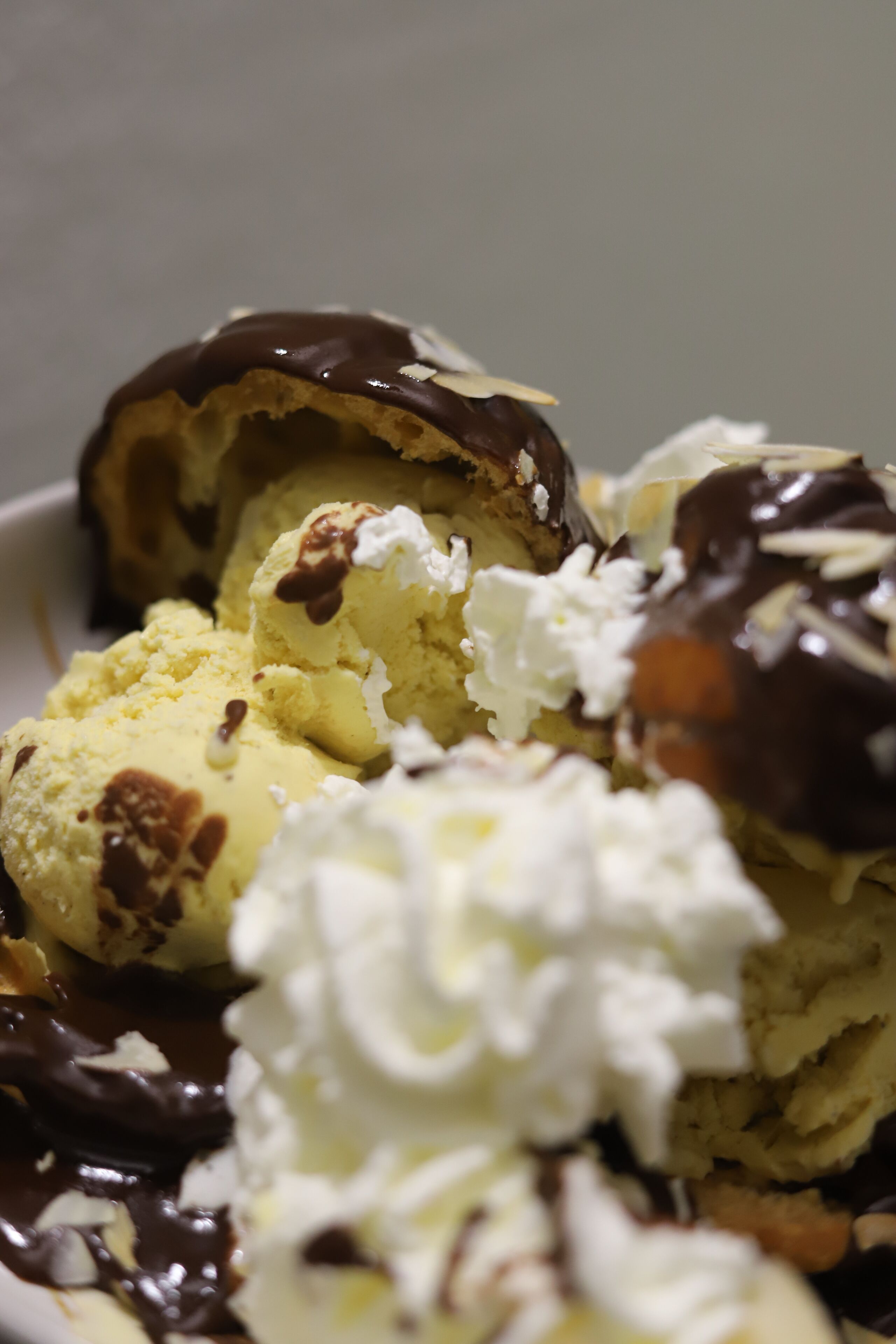 A dessert with ice cream, whipped cream, and chocolate sauce.
