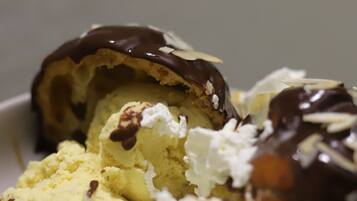Un dessert composé de crème glacée, de crème fouettée et de sauce au chocolat.