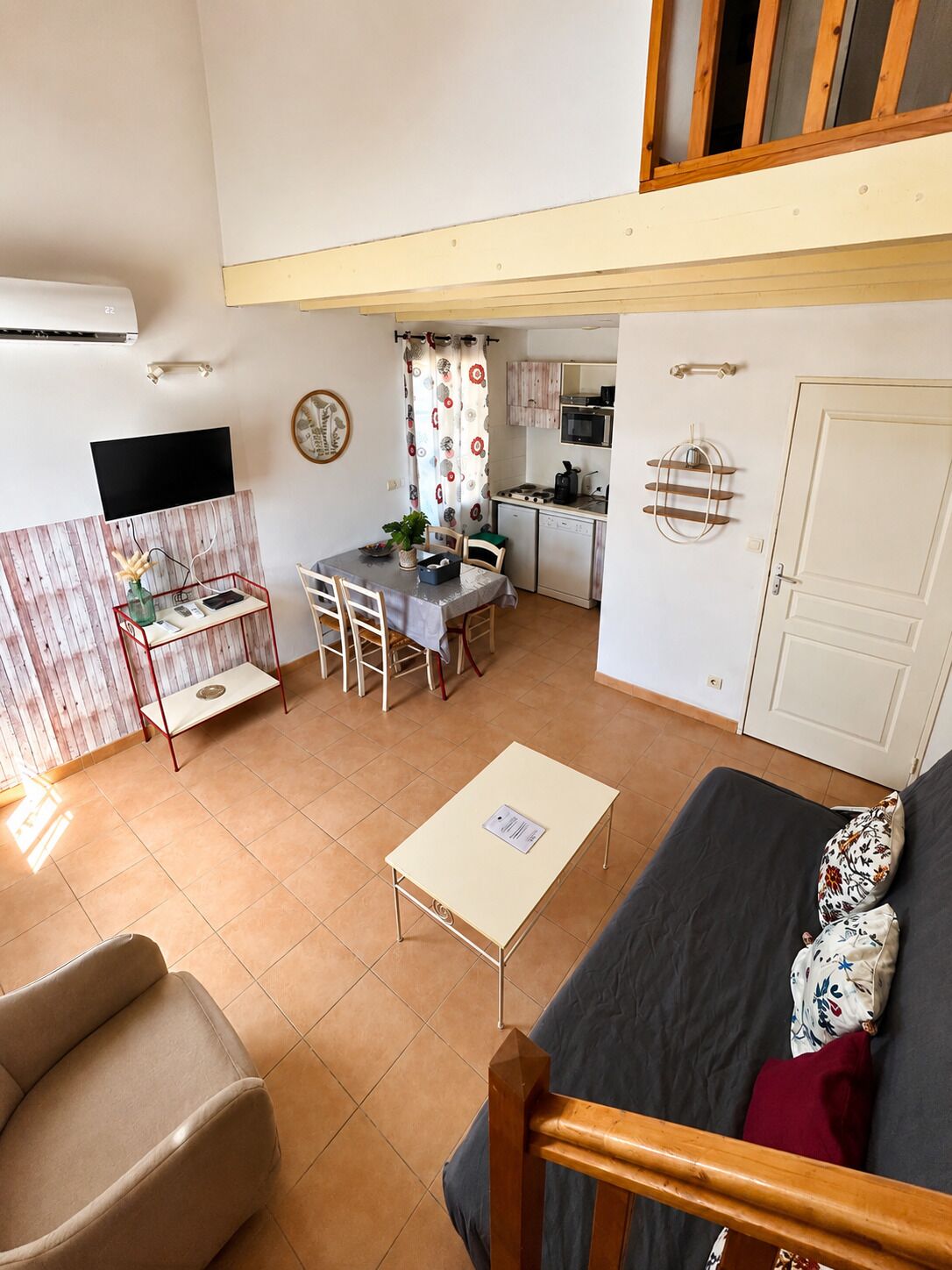Um espaço compacto com área de jantar, cozinha compacta e sofá.