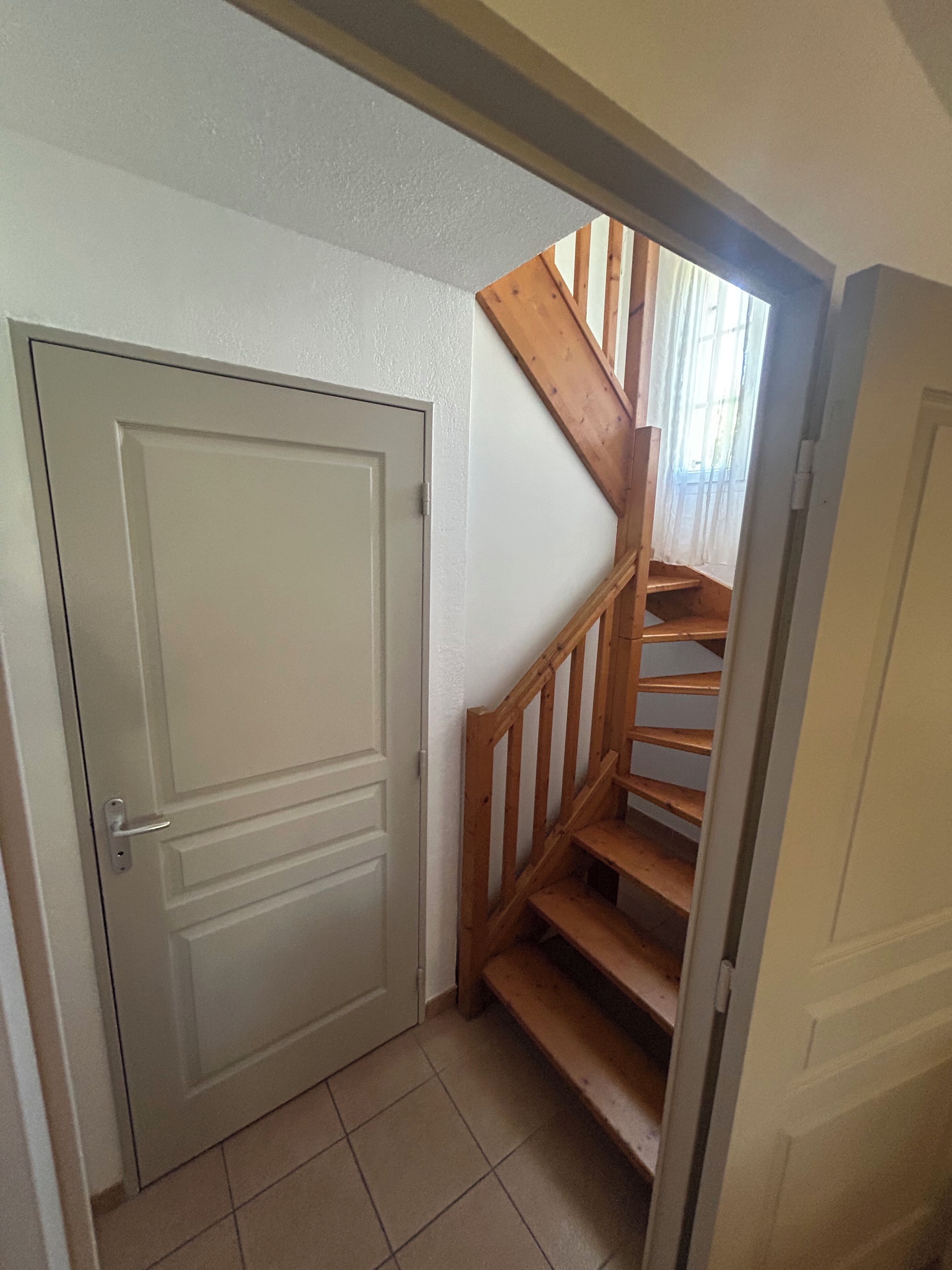 Una escalera con barandillas de madera que lleva a una puerta.
