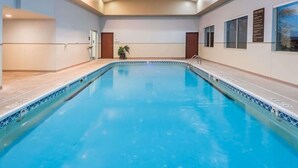 An indoor swimming pool with clear water, surrounded by walls with windows and a ceiling with recessed lighting. - Seasons Inn Suites Highland (Highland)