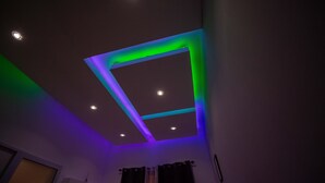 Un plafond doté d’un éclairage encastré et d’un luminaire aux formes géométriques.