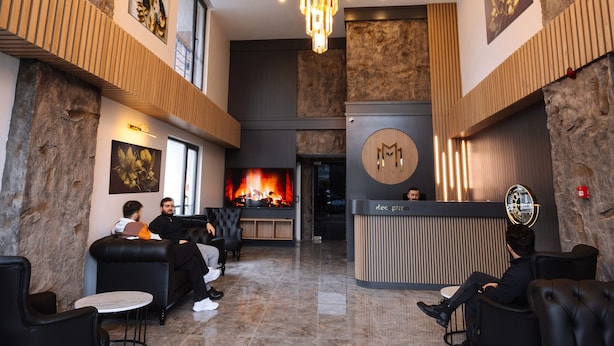 A lobby with a chandelier, seating area, reception desk, and a fireplace. - Meyzi Hotel (Arnavutköy)