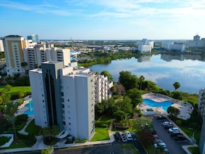A high-rise hotel with a swimming pool and a view of a lake. - Modern 2Bed/2Bath Home w/Private Terrace & Kitchen - Apartment (Orlando)