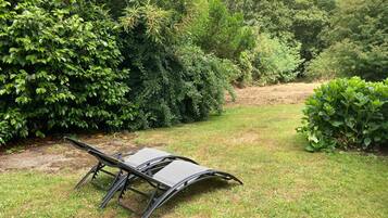 Een tuin met een metalen bank.