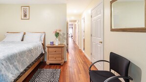 Une chambre à coucher avec un lit, une table de chevet, une chaise et un miroir.