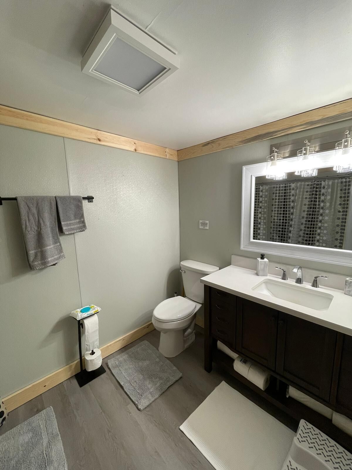 A modern bathroom with a toilet, sink, and mirror.